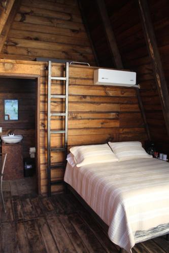 a bedroom with a bed with a ladder and a sink at Cabañas Hacienda de Letras in San Luis de Letras