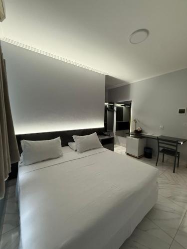 a large white bed in a room with a desk at PUMMA BUDGET HOTEL in Canaã dos Carajás