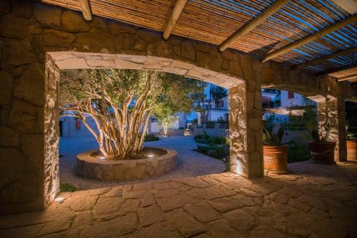 Casapueblo Rent Cachagua CP 18 في Cachagua: قوس حجري مع شجرة في الفناء