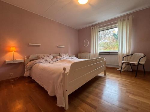 una camera da letto con un letto bianco e una finestra di Kåhögsberget a Jonsered