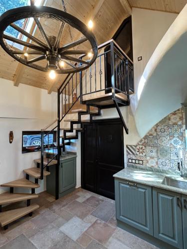 a spiral staircase in a kitchen with a chandelier at Balaton Cottage - Your Hide Away in Cserszegtomaj