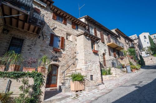 an old stone building on the side of a street at Torretta dependance in Assisi