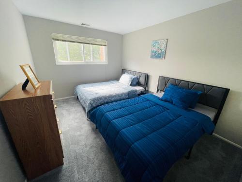 Elkins ParkにあるComfort 2br2ba Contact Us Discountのベッドルーム1室(青いシーツが備わるベッド2台付)