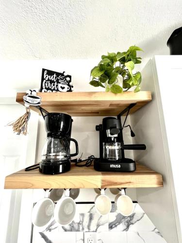 a shelf with a coffee maker and coffee cups on it at Lovely and Private Studio