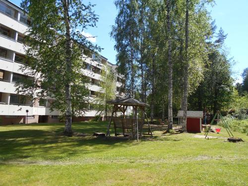 a park with a swing set in the grass at Laajavuori Apartment in Jyväskylä