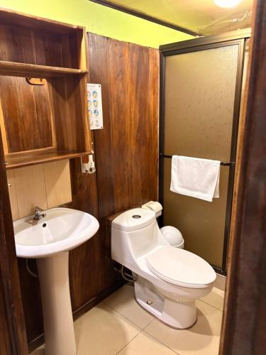 a bathroom with a toilet and a sink at Hospedaje Angeluz in Quesada