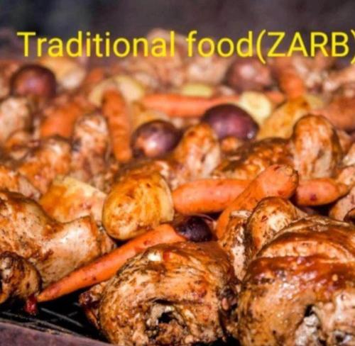 a pile of food with potatoes carrots and meat at Rum Aranda camp &Bubbles Hotel in Wadi Rum