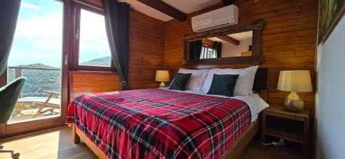 a bedroom with a bed and a large window at Chalet Vito - Where Luxury Meets Tranquility in Gregurić Breg