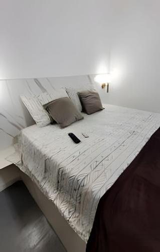 a white bed with a cell phone sitting on it at Pousada Gaturama Village in Corumbá