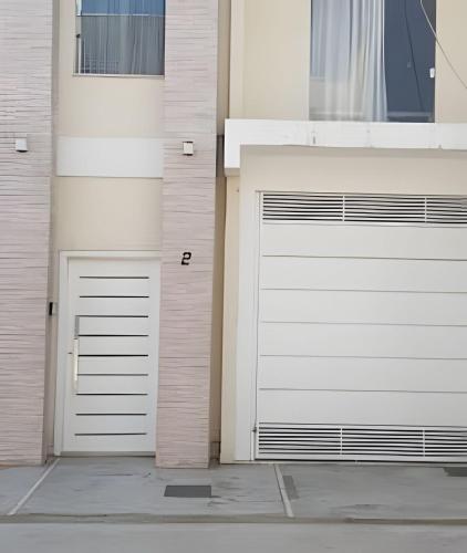 two garage doors on the side of a building at Sobrado 4 amplo e confortável in Corumbá