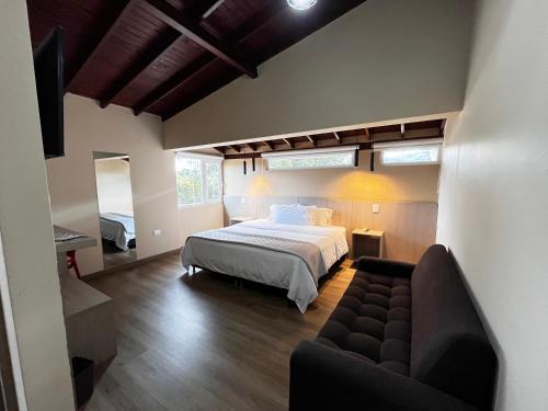 リオネグロにあるHotel & Golf Isak Aeropuertoのベッドとソファのある寝室