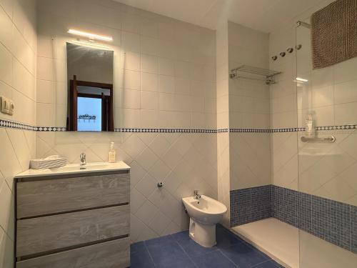 a bathroom with a sink and a toilet and a mirror at ModernLux in Bormujos