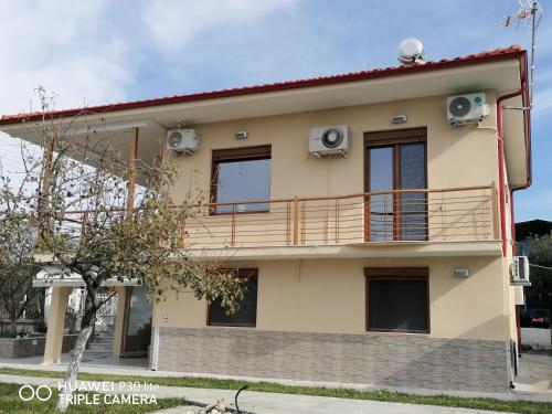 una casa con un balcón encima en Villa Anastasia Nir, en Nea Iraklia