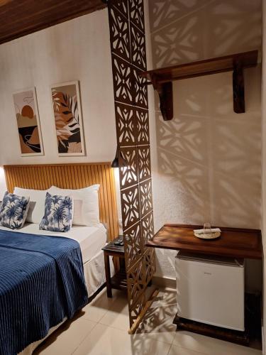 a hotel room with a bed and a table at Pousada Schueng in Trindade