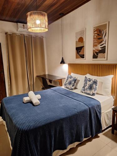 a bedroom with a bed with a blue blanket at Pousada Schueng in Trindade
