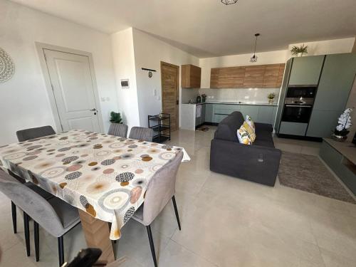 a kitchen and a living room with a table and a couch at PrimeRose Penthouse in Sannat