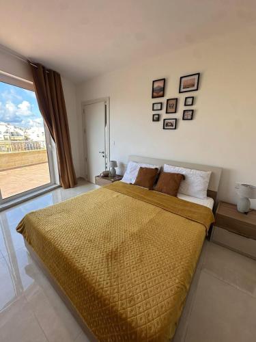 a bedroom with a large bed with a large window at Penthouse with Jacuzzi -Sannat in Sannat