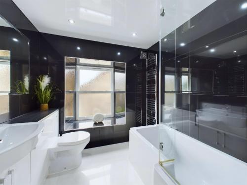 a bathroom with two sinks and a toilet and a shower at Queen Elizabeth Penthouse Sleeps 6-8 in Stanhope