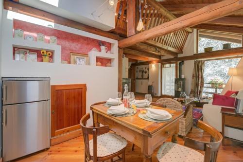 Una cocina y un comedor con mesa y sillas de madera. en Romito Lodge Apartment Mountain Retreat - Happy Rentals, en Cesana Torinese