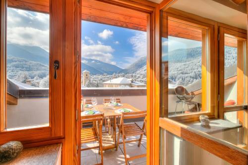 ein Esszimmer mit einem Tisch und Bergblick in der Unterkunft Sunny Penthouse - Happy Rentals in Oulx