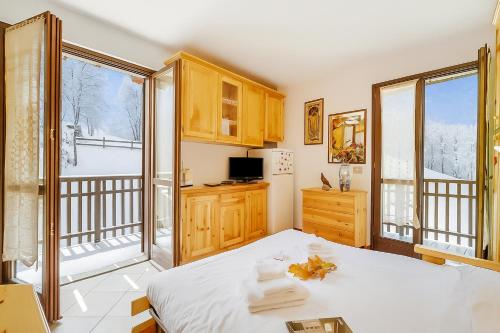 a bedroom with a bed and a balcony at Relax In Pineta - Happy Rentals in Oulx