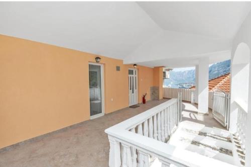a balcony of a house with mountains in the background at Apartman Tamara i Tijana in Škaljari