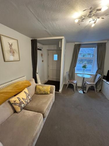 a living room with a couch and a table at 1, Bank End Cottages in Ingleton