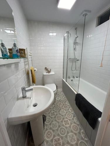 a white bathroom with a sink and a shower at 1, Bank End Cottages in Ingleton