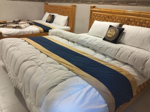 a group of three beds in a room at Neelam Water View Hotel in Kundālshai
