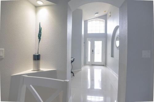 a hallway with white walls and a vase on a table at Casa Kissimmee in Orlando