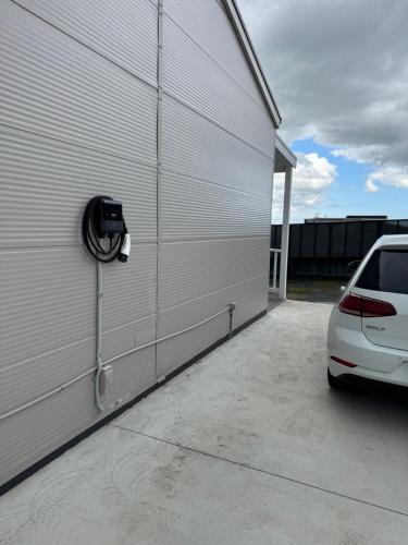 a white car parked next to a garage at Coastal Sanctuary, EV, Pet Firendly with Fireplace, wood provided Just 50m to Kilcunda Beach and 100m to the Ocean View Hotel The Sticks and Copper Door Kitchen Accessibility Friendly in Kilcunda