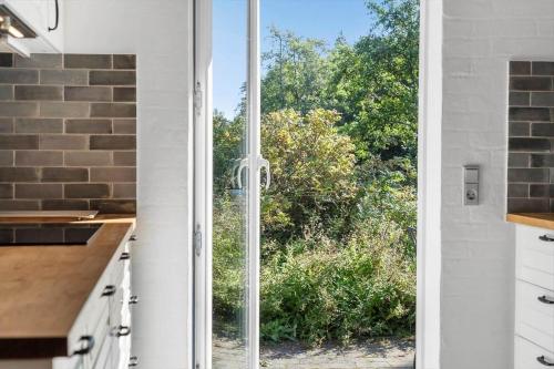 een keuken met een glazen schuifdeur die naar een tuin leidt bij 852-Bedsted-Thy-Istrupvej-35 in Stenbjerg