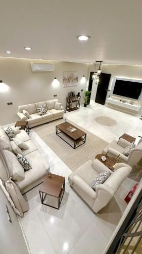 a large living room with couches and tables in it at فيلا آنسي Villa Annecy in AlUla
