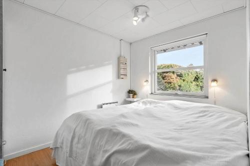 a white bedroom with a bed and a window at 30194-Malling-Fjordvej-26 in Norsminde
