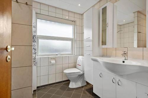 a bathroom with a toilet and a sink and a window at 30194-Malling-Fjordvej-26 in Norsminde