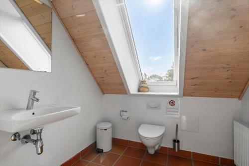 a bathroom with a toilet and a sink and a window at 20424-Samso-Besser-Kirkevej-4-C in Langemark