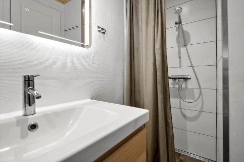 a white bathroom with a sink and a shower at 30732-Odder-Skovgardsparken-32 in Amstrup