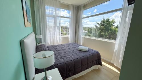 a bedroom with a bed and a large window at Cariló Sul Mare in Carilo
