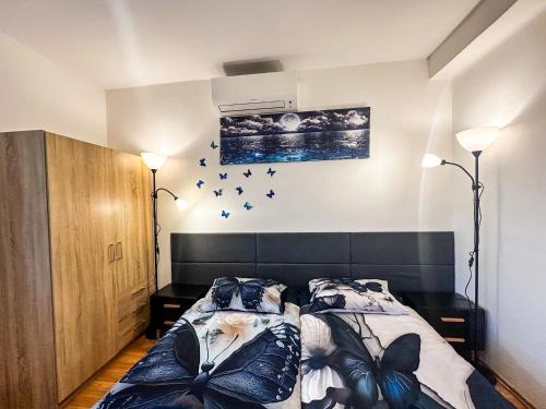 Un dormitorio con una cama con pájaros en la pared. en IN Apartments, en Prešov