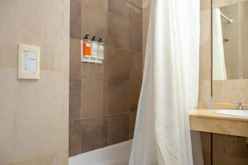 a bathroom with a shower curtain and a sink at Cariló Sul Mare in Carilo