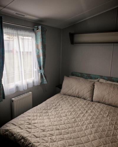 a bedroom with a bed and a window at Primrose Valley Primrose field 4 in Filey