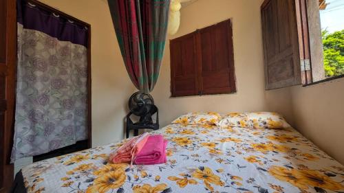 a bed with a purse on it in a bedroom at Hospedagem Tia Lene Pacoval Soure in Soure