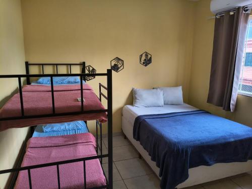 a bedroom with two bunk beds and a window at Kitinet Verolme AFP 1 in Angra dos Reis