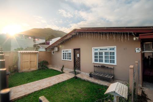 a small house with a bench in a yard at Suítes 91 in Penha