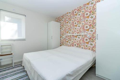 a bedroom with a white bed and a floral wallpaper at BLE833-Lyckeby-Knoesoevaegen-98 in Lyckeby