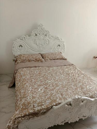 Bett mit verziertem Kopfteil in einem Schlafzimmer in der Unterkunft Amplio departamento para 10 personas in Cuenca