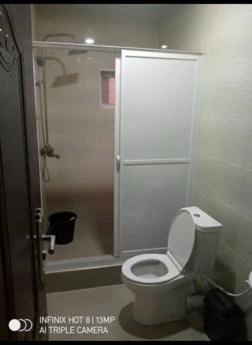 a bathroom with a toilet and a shower at Rosecourt Hotel & Suites in Enugu