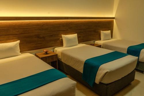 a room with three beds in a hotel room at Antawa Classic in Moquegua