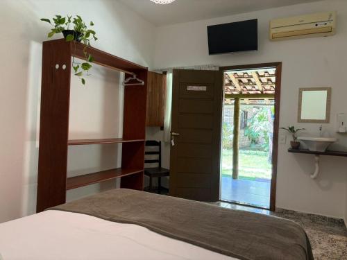 a bedroom with a bed and a tv on the wall at Pousada Arraial dos Sonhos in Arraial d'Ajuda