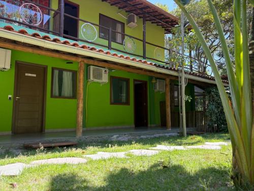a green house with a building at Pousada Arraial dos Sonhos in Arraial d'Ajuda